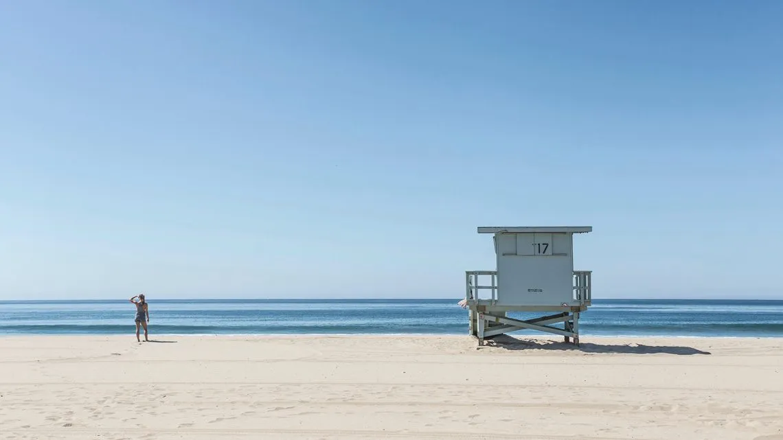 Rettungsschwimmerturm an einem menschenleeren Strand, ruhige See